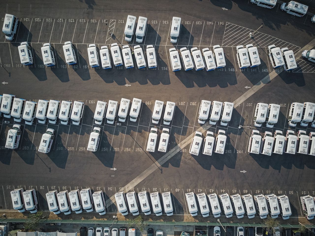 Home Aerial perspective showcasing a parking lot filled with parked camper vans.